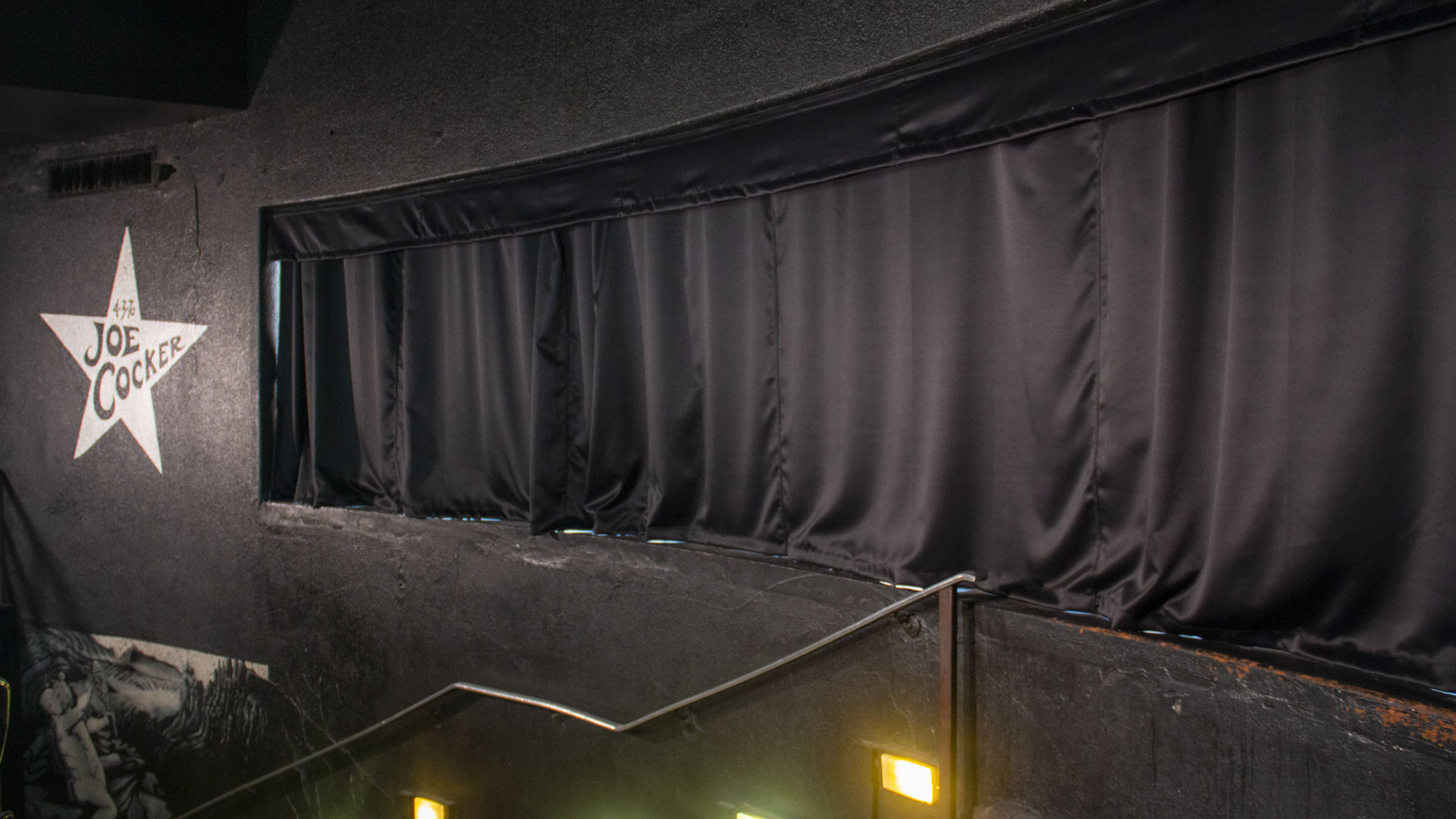 A sliding curtain track system installed in a window at a jazz club